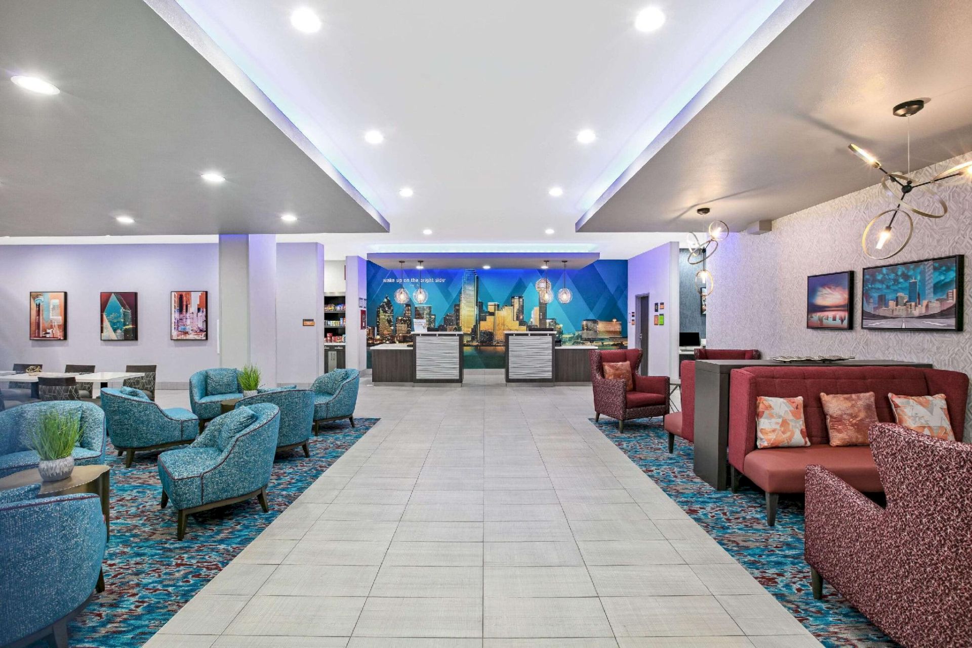 The image shows a modern hotel lobby with blue and red seating, a tiled floor, and a reception desk in the background, ending the sentence.