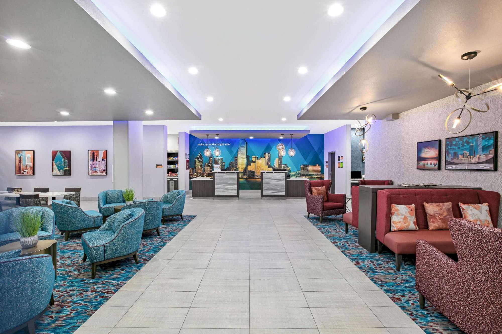 The image shows a modern hotel lobby with blue and red seating, a tiled floor, and a reception desk in the background, ending the sentence.